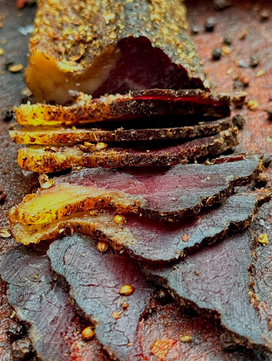 Slices of cured meat arranged in a wooden bowl.